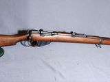 un vieux fusil en bois surmonté d'un chapeau vert