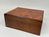 une petite boîte en bois avec un couvercle sur une surface blanche