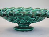 a green vase that has a bunch of flowers in it