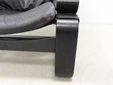 black leather lounge chair with foot rest and foot rest on a white floor