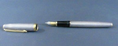 un stylo argenté et un stylo noir sur un fond bleu