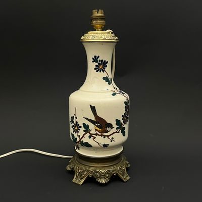 un vase blanc orné d'un oiseau, posé sur une table