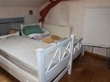 a bed with a white frame in a room with wood floors