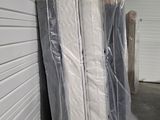 une pile de matelas emballés dans du plastique dans un débarras