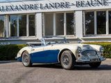 a blue and white sports car parked in front of a building