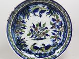 une assiette bleue et blanche décorée de fleurs et de feuilles
