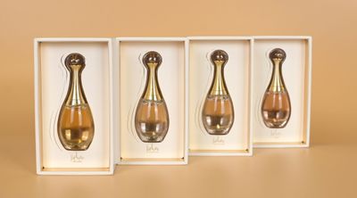 trois flacons de parfum dans une boîte blanche sur fond marron