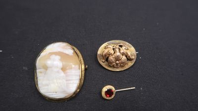 un gros plan sur une broche et une paire de boucles d'oreilles