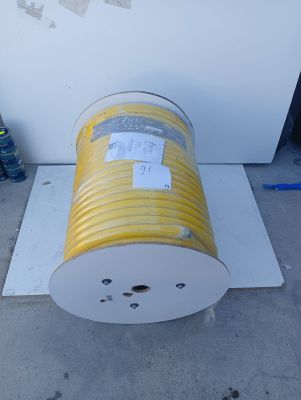 a yellow hose sitting on the ground next to a white box
