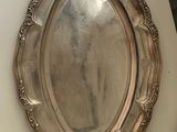 a silver plate on a table with a mirror on it