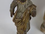 two figurines of a man and a woman on a white surface
