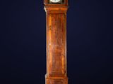 a tall wooden grandfather clock on a dark blue background