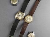 three different types of watches on a gray surface with a black strap