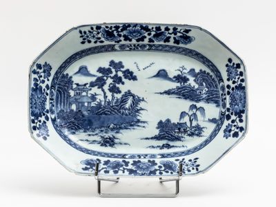 blue and white platter with a landscape scene on it