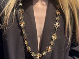 the woman is wearing a necklace that has flowers on it