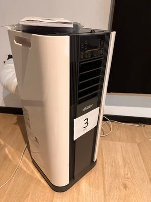 a small air conditioner sitting on the floor next to a wall