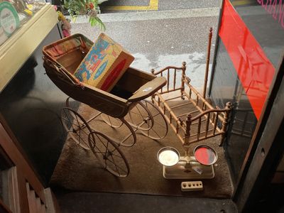 une poussette miniature avec des livres exposés dans une vitrine