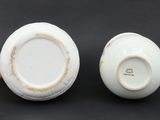 pair of white porcelain vases sitting on top of a black table
