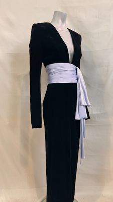 a black and white dress with a white sash on a mannequin base