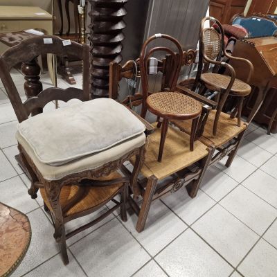 several chairs and a table in a room with a lot of furniture