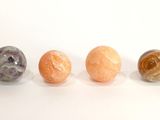 Trois billes de marbre sont alignées sur une surface blanche