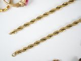 a lot of gold jewelry on a white table