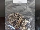 a bag of silver metal charms sitting on a table