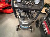 un petit compresseur d'air posé par terre dans le garage