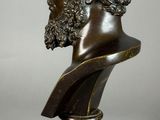a bronze bust of a man with curly hair and a beard