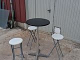 three stools and a table in front of a building