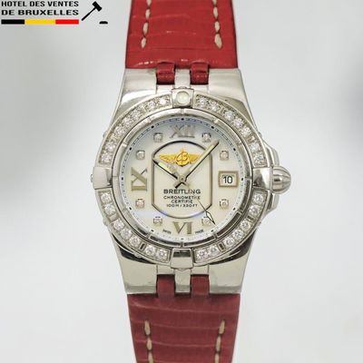 un gros plan d'une montre avec un bracelet rouge