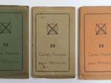three old books are lined up in a row on a white surface