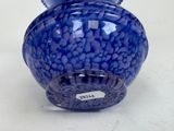 a blue vase that has a lot of blue pebbles in it