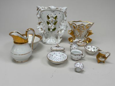 a white and gold tea set on a white table