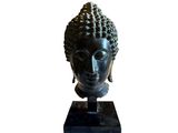 the head of a statue of a buddha on a black base