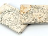 deux vieux livres posés l'un sur l'autre sur une surface blanche