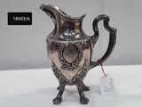 a silver pitcher on a table with a price tag