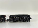 two black toy trains sitting side by side on a white surface