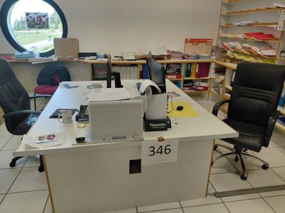 un bureau avec un ordinateur et une chaise dans une pièce