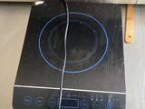 a black stove top with a blue burner on it