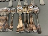 a lot of silver spoons and forks on the table
