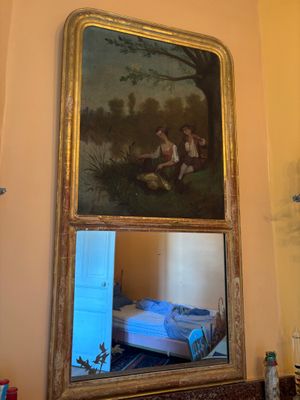 un miroir et un tableau accrochés au mur au-dessus d'un lit