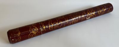 un vieux livre orné d'inscriptions dorées, posé sur une surface blanche