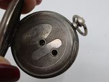 a person holding a silver pocket watch in their hand
