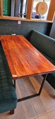 a wooden table with a bench in the corner of the room