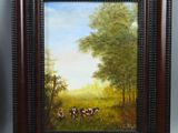 two framed paintings of cows in a pasture with trees in the background