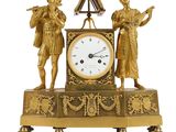 une horloge en or surmontée de deux figurines