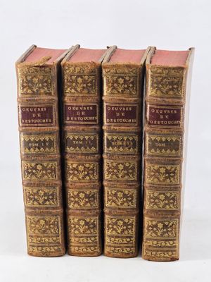 three old books sitting on top of each other on a white surface