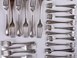 many forks and spoons laid out on the table