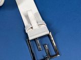 white leather belt with silver buckle on a blue background